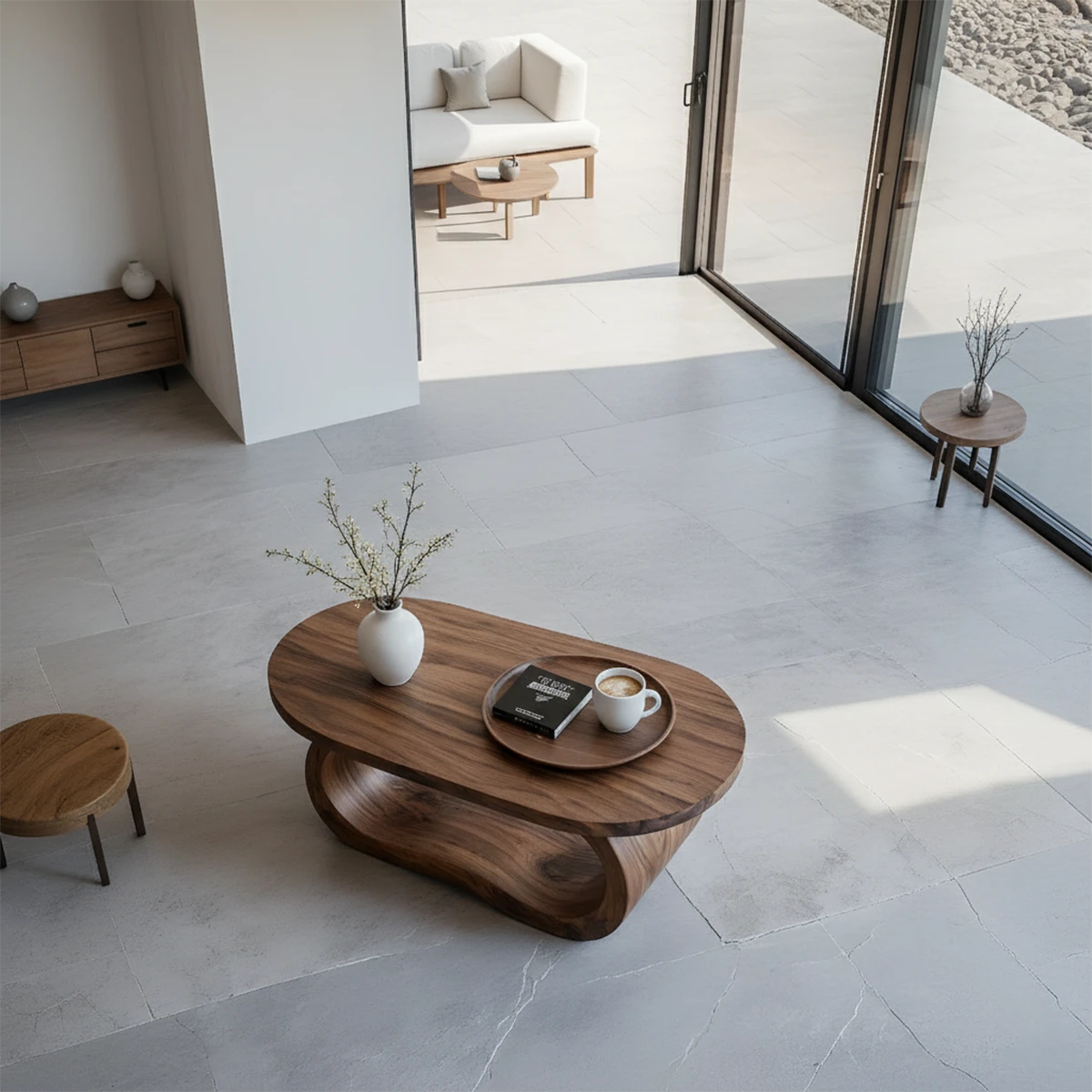 Walnut look coffee table with sculptural curved base and seamless top in a soft neutral home interior