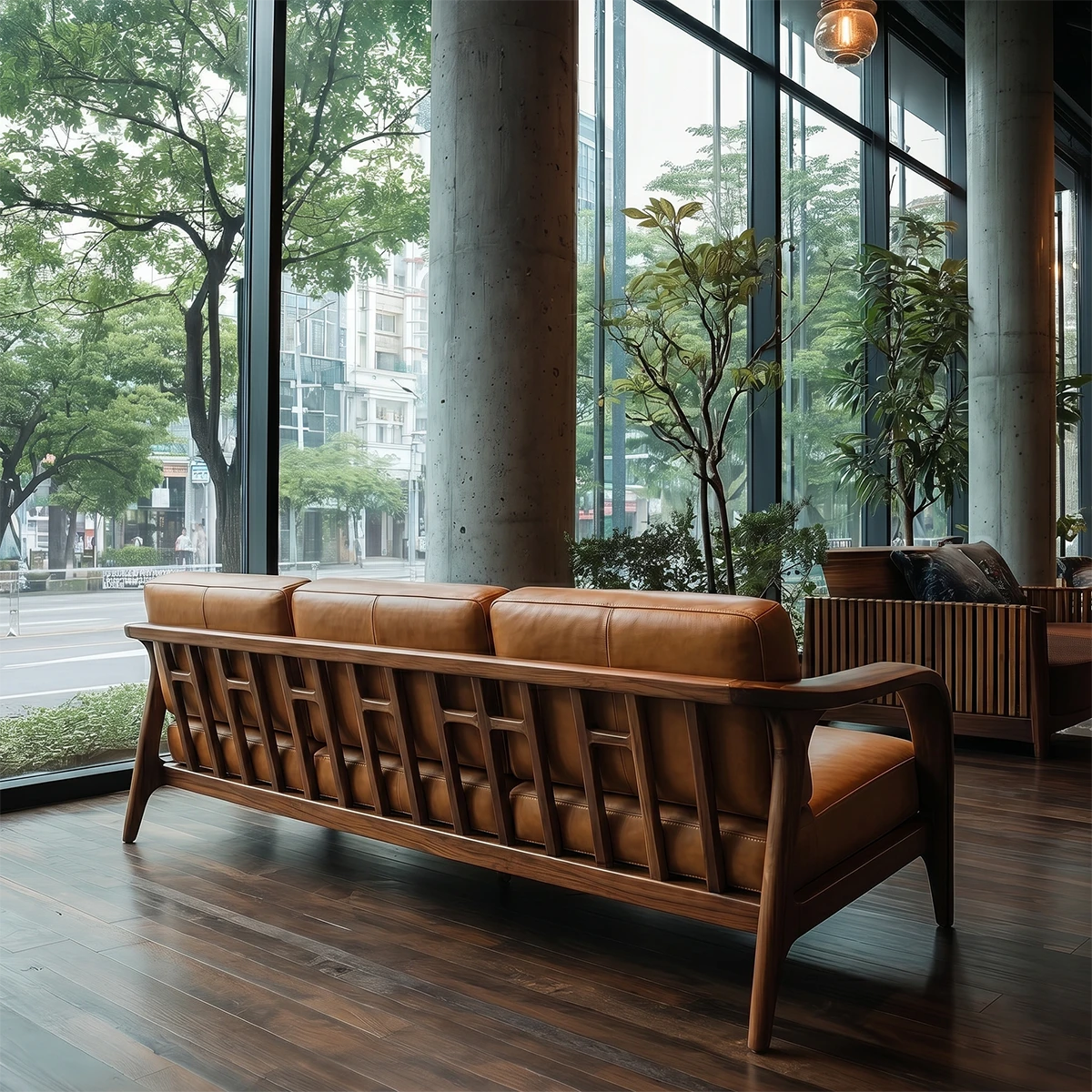Elegant living room sofa with curved wooden arms and soft leather seating near urban window view