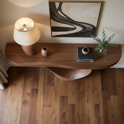 Elegant console table with sculptural wood base enhances this clean and softly lit interior