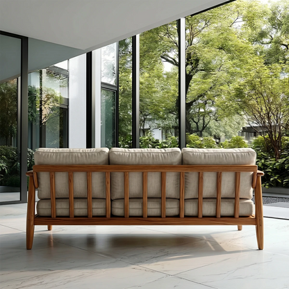 Elegant modern couch with upholstered cushions and smooth wood arms in nature filled home setting