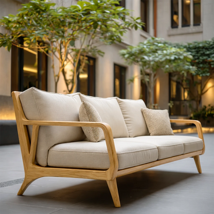 Cozy three seater sofa with neutral fabric cushions and natural wood frame in calm outdoor space