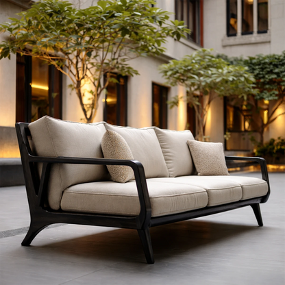 Designer lounge sofa with curved wooden arms and soft fabric seating in architectural courtyard