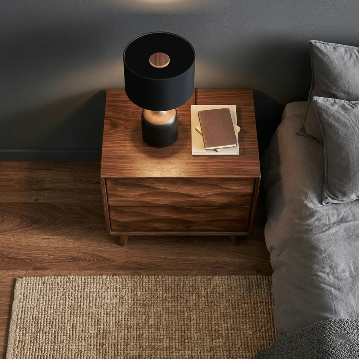 Compact bedroom side table designed with sculptural drawer detail and walnut tone finish