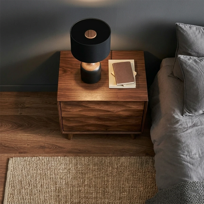 Compact bedroom side table designed with sculptural drawer detail and walnut tone finish