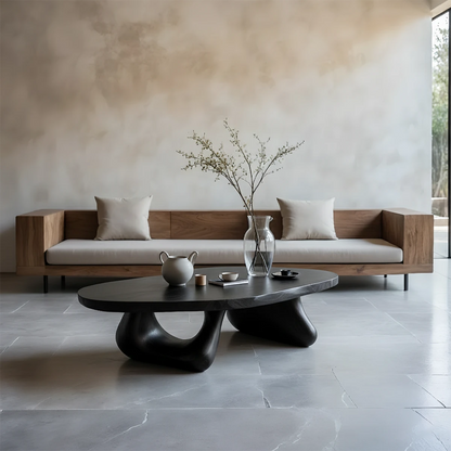 Black coffee table with natural grain detail and sculptural base in a refined modern interior