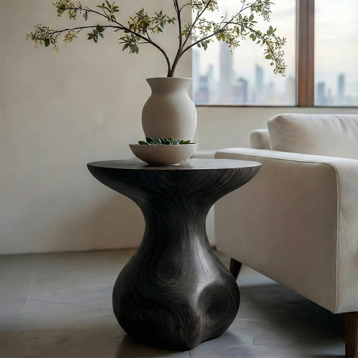 A small end table in black color with curved form for compact and functional spaces