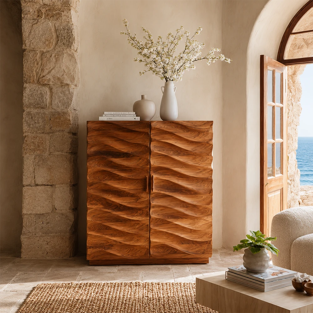 Wooden cabinet with wavy design in a room with stone wall and open door showing sea view