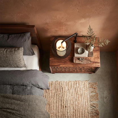 Compact bedside storage unit designed with sculptural vertical detail and walnut tone finish